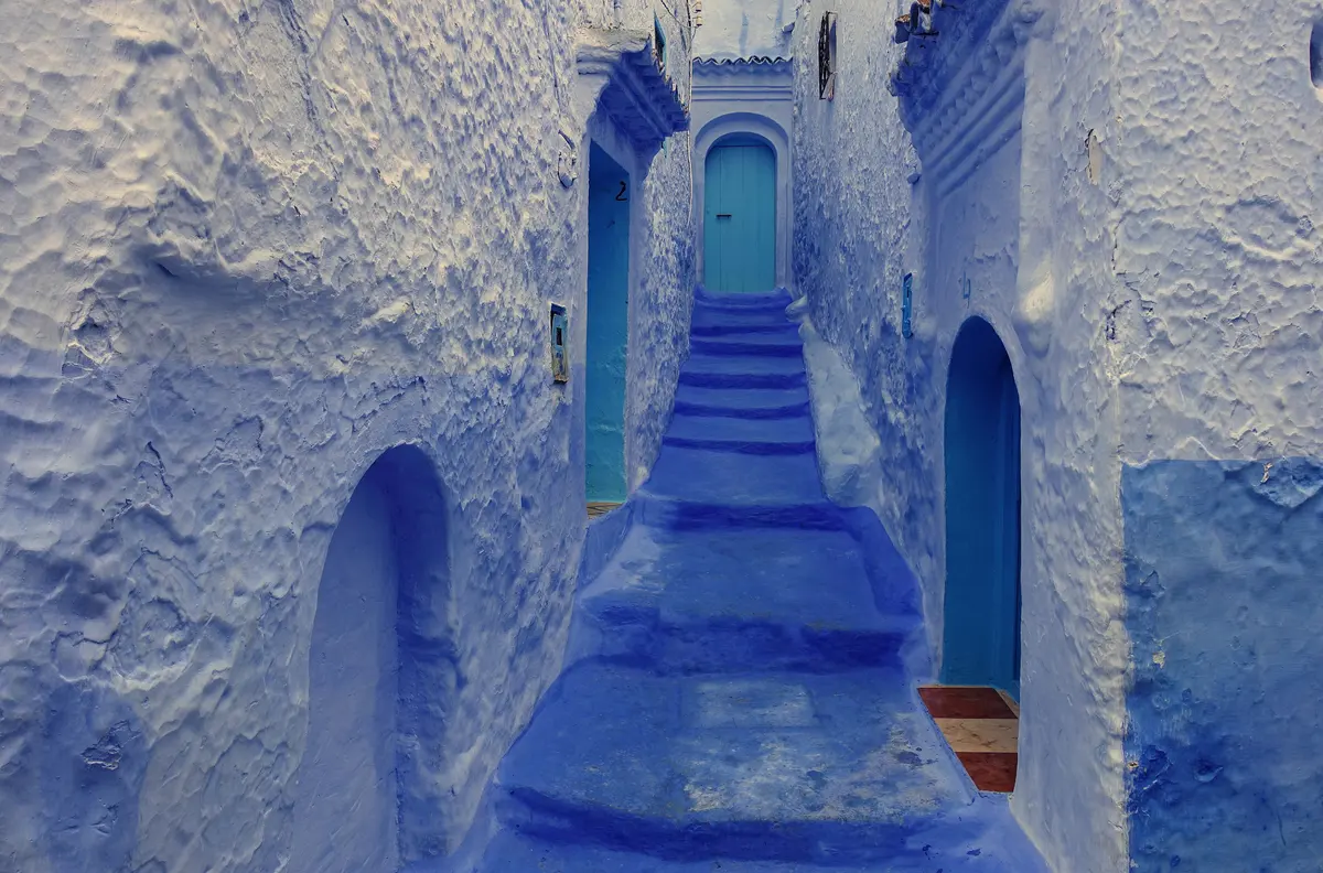 Blue steps and a studded wooden door in Chefchaouen
